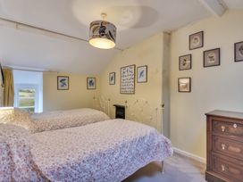 A bedroom with two single beds a wooden chest of drawers and bird-themed wall art at Tan Y Clogwyn in Dolwyddelan near Betws-Y-Coed