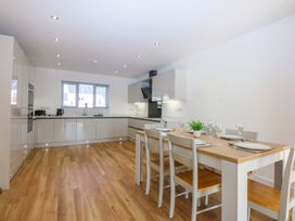 A kitchen with a dining table and chairs at 15 Llys Tegeirian Llangristiolus near Llangefni
