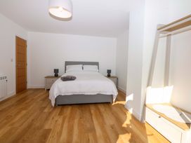 A bedroom with a bed and nightstand at 15 Llys Tegeirian in Llangristiolus near Llangefni