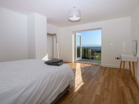 A bedroom with a bed and a wardrobe at 15 Llys Tegeirian in Llangristiolus near Llangefni