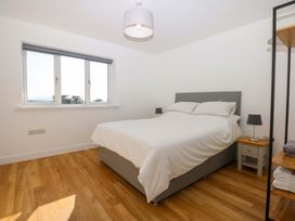 A bedroom with a bed and bedside table at 15 Llys Tegeirian in Llangristiolus near Llangefni
