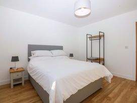 A bedroom with a bed and a bedside table at 15 Llys Tegeirian in Llangristiolus near Llangefni
