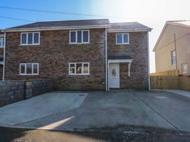 A house with a driveway at 15 Llys Tegeirian in Llangristiolus near Llangefni