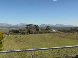 A view of mountains and a field with cows at 15 Llys Tegeirian Llangristiolus near Llangefni