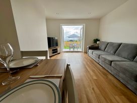 A living room with a sofa and television at Golygfa in Llangristiolus near Llangefni