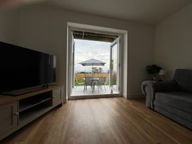 A living room with a television and sofa at Golygfa in Llangristiolus near Llangefni