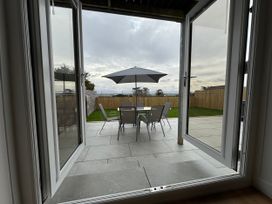 An outdoor area with a table and chairs under an umbrella at Golygfa in Llangristiolus near Llangefni