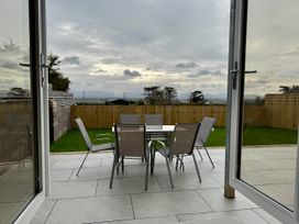 A garden with a table and chairs at Golygfa in Llangristiolus near Llangefni