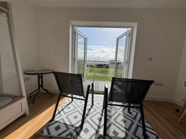 A room with chairs and a table overlooking a landscape at Golygfa in Llangristiolus near Llangefni