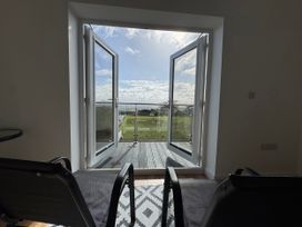 A living room with a view of a balcony at Golygfa Llangristiolus near Llangefni