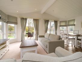 A living room with sofas a coffee table and a dining table with chairs at Lakeview Lodge in Forton near Garstang