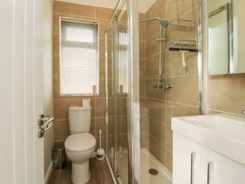 A bathroom with a toilet a shower with glass doors and a sink with cabinet at Lakeview Lodge in Forton near Garstang