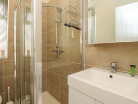 A bathroom with a shower enclosure a sink with a faucet and a tube of cream on the counter at Lakeview Lodge in Forton near Garstang