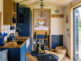 A kitchen and sleeping area in Lillie's Shepherds Hut at Shepherds Lodge Retreat and Wellness Bottesford near Redmile and Vale of Belvoir