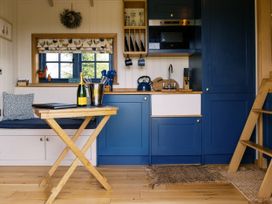 A kitchen with a table and champagne at Lillie's Shepherds Hut at Shepherds Lodge Retreat and Wellness Bottesford near Redmile and Vale of Belvoir