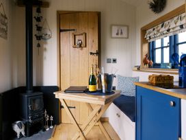 A small indoor seating area with a wood stove at Lillie's Shepherds Hut at Shepherds Lodge Retreat and Wellness Bottesford near Redmile and Vale of Belvoir