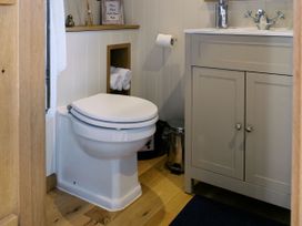 A bathroom featuring a toilet, sink and cabinet at Lillie's Shepherds Hut at Shepherds Lodge Retreat and Wellness Bottesford near Redmile and Vale of Belvoir