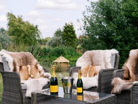An outdoor seating area with chairs, table, and champagne at Lillie's Shepherds Hut at Shepherds Lodge Retreat and Wellness Bottesford near Redmile and Vale of Belvoir