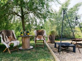 A garden seating area with two chairs and a table at Lillie's Shepherds Hut at Shepherds Lodge Retreat and Wellness Bottesford near Redmile and Vale of Belvoir