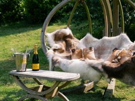 A hammock with fur throws and champagne at Lillie's Shepherds Hut at Shepherds Lodge Retreat and Wellness Bottesford near Redmile and Vale of Belvoir