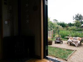 A living room with a view of outdoor seating at Poppie's Shepherds Hut at Shepherds Lodge Retreat and Wellness near Bottesford