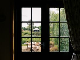 A view from a window showing a garden with a table and chairs at Poppie's Shepherds Hut at Shepherds Lodge Retreat and Wellness Bottesford near Redmile and Vale of Belvoir