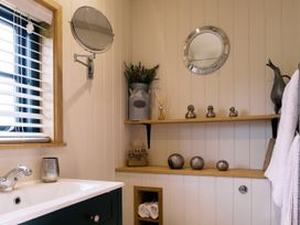 A bathroom with shelves and a sink at Poppie's Shepherds Hut at Shepherds Lodge Retreat and Wellness, Bottesford near Redmile and Vale of Belvoir