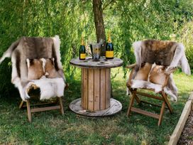 An outdoor seating area with chairs and a table at Poppie's Shepherds Hut at Shepherds Lodge Retreat and Wellness Bottesford near Redmile and Vale of Belvoir