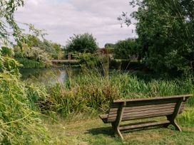 A bench overlooking a pond and bridge at Poppie's Shepherds Hut at Shepherds Lodge Retreat and Wellness Bottesford near Redmile and Vale of Belvoir