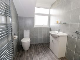 A bathroom with a toilet sink cabinet and heated towel rail at Bwthyn Y Mor in Tal-Y-Bont