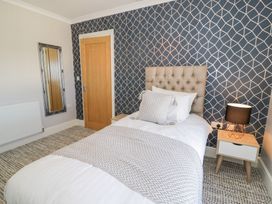 A bedroom with a single bed and a bedside table with a lamp at Bwthyn Y Mor in Tal-Y-Bont