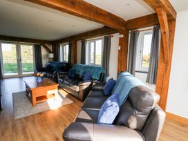 A living room with leather sofas wooden beams and a coffee table at Yr Adfa in Llangeitho near Tregaron