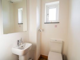 A bathroom with a sink a mirror a toilet and a window at Yr Adfa in Llangeitho near Tregaron