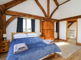 A bedroom with a wooden bed covered with blue bedding and towels on the bed at Yr Adfa in Llangeitho near Tregaron