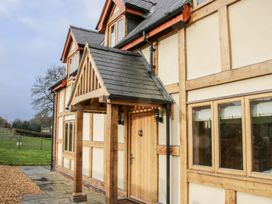 The exterior of a timber framed house with a wooden front door and a porch roof with windows at White House in Montgomery