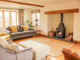 A living room with a wood burning stove sofa armchair ottoman and woven rugs at White House in Montgomery