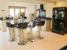 A kitchen with black counter stools around a central island with flowers and candles at White House in Montgomery