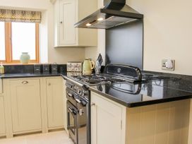 A kitchen with black countertops a gas stove a kettle toaster and containers on the counter at White House in Montgomery