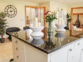 A kitchen island with candles and flowers a wall clock and black chairs in background at White House in Montgomery
