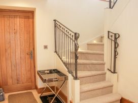 A carpeted staircase with metal railings next to a wooden door and a small mirrored table at White House in Montgomery