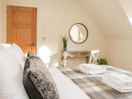 A bedroom with a bed with pillows and folded towels a wooden door a wall mirror and a wooden desk with a potted plant at White House in Montgomery