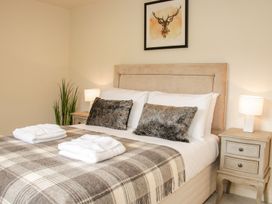 A bedroom with a double bed two bedside tables with lamps a plant and a framed deer picture at White House in Montgomery