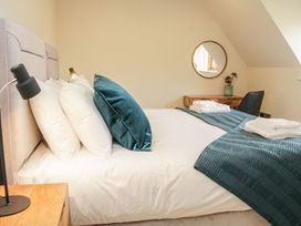A bedroom with a bed with pillows and blue blankets a wooden desk with a plant and towels and a round mirror on the wall at White House in Montgomery