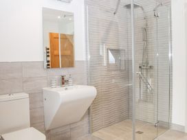 A bathroom with a toilet a wall-mounted sink a mirror and a glass-enclosed shower at White House in Montgomery