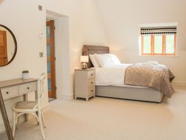A bedroom with a bed bedside table lamp desk chair and round mirror at White House in Montgomery
