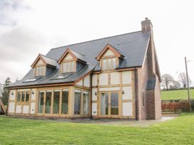 A two-story house with wooden framed windows and glass doors on a lawn at White House in Montgomery