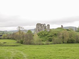 Ruins of a stone castle on a grassy hill surrounded by trees and fields at White House in Montgomery