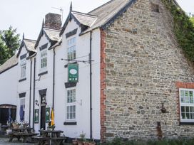A building with white and stone walls and outdoor picnic tables with umbrellas at White House in Montgomery