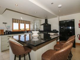 A kitchen with a refrigerator and bar stools at White House in Montgomery
