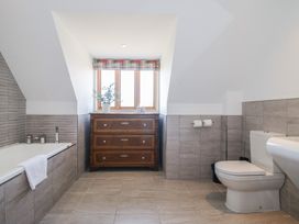 A bathroom with a bathtub, toilet, and drawer at White House in Montgomery